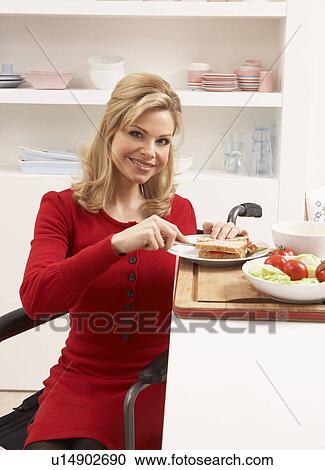 Stock Image - Disabled Woman Making Sandwich In Kitchen. Fotosearch