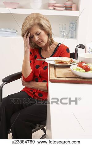 Stock Photo - Distressed Disabled Senior Woman Making Sandwich In Kitchen. Fotosearch