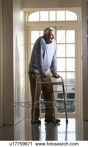 Stock Image - Elderly Senior Man Using Walking Frame. Fotosearch
