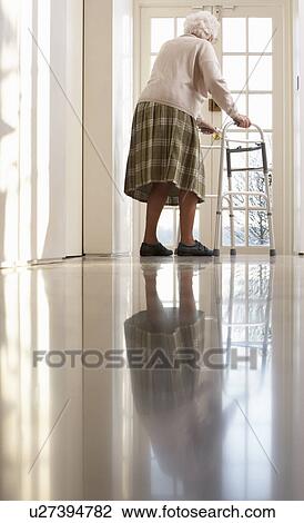 Stock Image - Elderly Senior Woman Using Walking Frame. Fotosearch