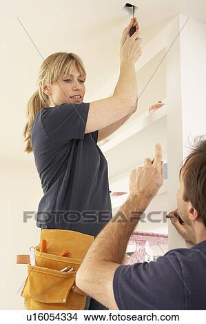 Picture - Electrician Teaching Apprentice To Install Light Fitting In Home. Fotosearch