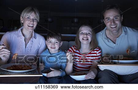 Family Enjoying Meal Whilst Watching TV View Large Photo Image Stock Photo - Family Enjoying Meal Whilst Watching TV. Fotosearch