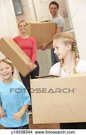Picture - Family happy on moving day carrying cardboard boxes. Fotosearch