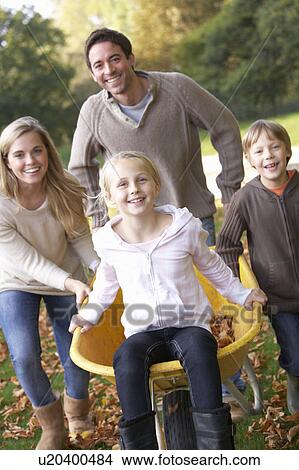 Family having fun with autumn leaves in garden View Large Photo Image Picture - Family having fun with autumn leaves in garden. Fotosearch