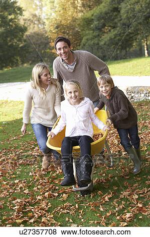 Family having fun with autumn leaves in garden View Large Photo Image Stock Photo - Family having fun with autumn leaves in garden. Fotosearch