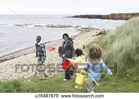 Family on beach collecting shells View Large Photo Image Stock Photo - Family on beach collecting shells. Fotosearch