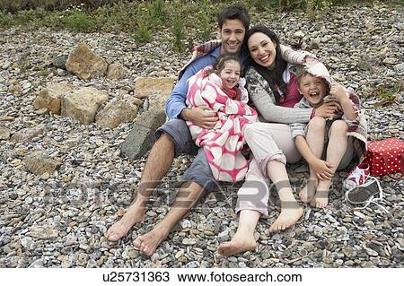 Stock Image - Family on beach with blankets. Fotosearch