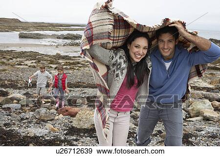 Stock Photo - Family on beach with blankets. Fotosearch
