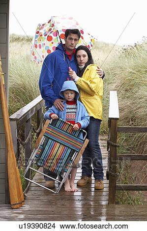 Picture - Family on beach with umbrella. Fotosearch