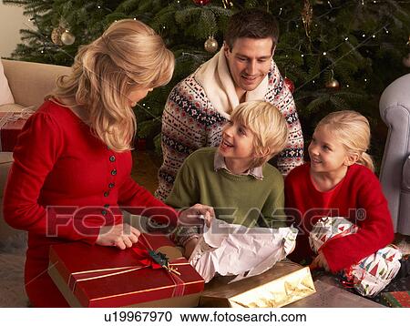 Stock Image - Family Opening Christmas Gifts At Home. Fotosearch