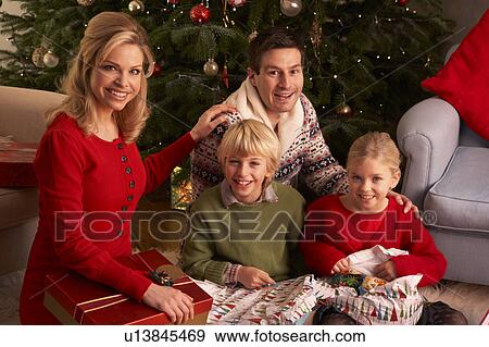 Stock Photo - Family Opening Christmas Gifts At Home. Fotosearch