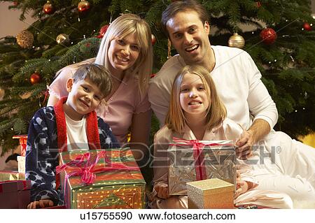 Family Opening Christmas Present In Front Of Tree View Large Photo Image Stock Image - Family Opening Christmas Present In Front Of Tree. Fotosearch