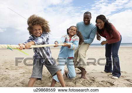 Family playing tug of war on beach View Large Photo Image Stock Photo - Family playing tug of war on beach. Fotosearch