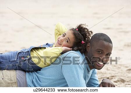 Father and daughter laying on beach View Large Photo Image Stock Image - Father and daughter laying on beach. Fotosearch