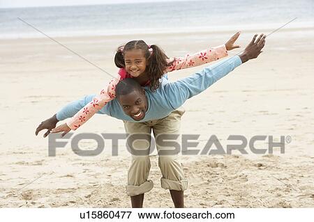 Stock Photo - Father and daughter playing on beach. Fotosearch