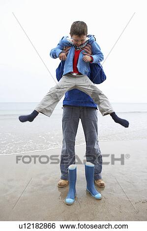 Stock Photograph - Father and son on beach. Fotosearch