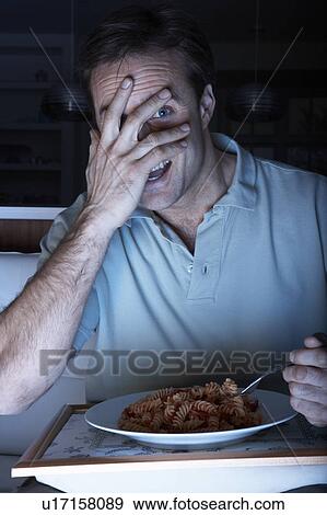 Frightened Man Enjoying Meal Whilst Watching TV View Large Photo Image Stock Photo - Frightened Man Enjoying Meal Whilst Watching TV. Fotosearch