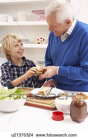 Picture - Grandfather And Grandson Making Sandwich In Kitchen. Fotosearch