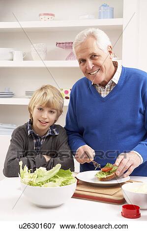 Stock Photo - Grandfather And Grandson Making Sandwich In Kitchen. Fotosearch