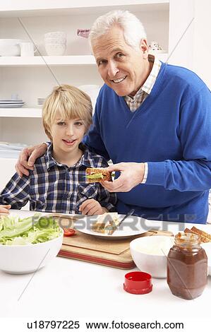 Stock Photography - Grandfather And Grandson Making Sandwich In Kitchen. Fotosearch