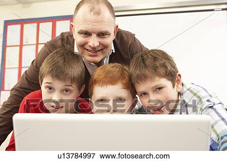 Stock Photo - Group Of Schoolboys In IT Class Using Computer. Fotosearch