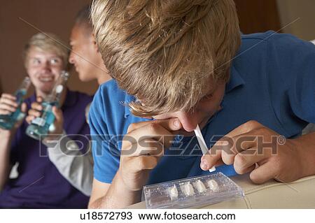Stock Image - Group Of Teenage Boys Taking Drugs At Home. Fotosearch