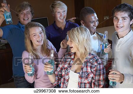 Stock Photo - Group Of Teenage Friends Dancing And Drinking Alcohol. Fotosearch