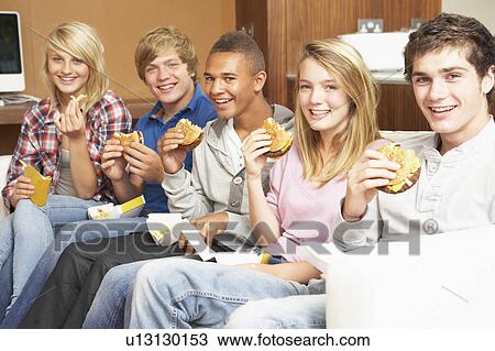 Group Of Teenage Friends Sitting On Sofa At Home Eating Fast Food View Large Photo Image Stock Image - Group Of Teenage Friends Sitting On Sofa At Home Eating Fast Food. Fotosearch