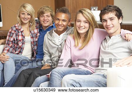 Stock Photo - Group Of Teenage Friends Sitting On Sofa At Home. Fotosearch
