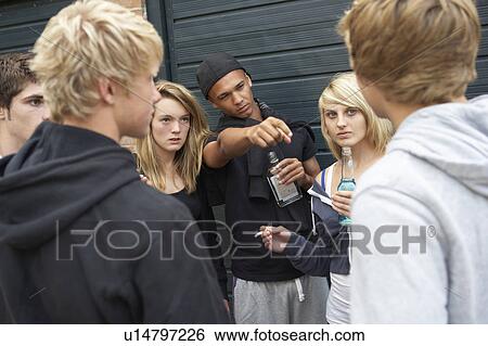 Stock Photograph - Group Of Threatening Teenagers Hanging Out Together Outside Drin. Fotosearch