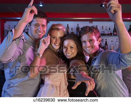 Stock Image - Group Of Young People Having Fun In Busy Bar. Fotosearch