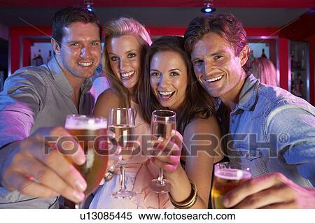 Stock Photography - Group Of Young People Having Fun In Busy Bar. Fotosearch