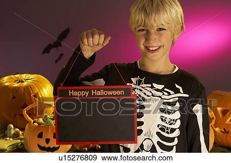 Stock Photo - Halloween party with a boy child holding sign. Fotosearch