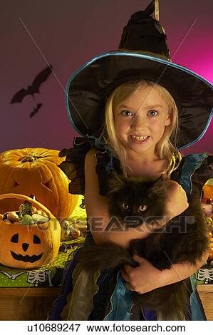 Halloween party with a child holding black cat in hand View Large Photo Image Stock Photo - Halloween party with a child holding black cat in hand. Fotosearch