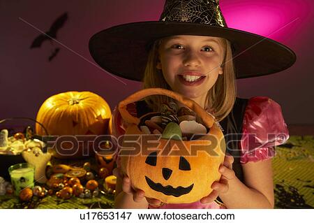 Stock Photo - Halloween party with a child showing candy. Fotosearch