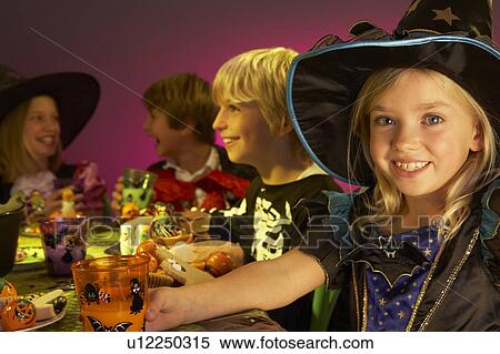 Stock Photography - Halloween party with children having fun in fancy costumes. Fotosearch