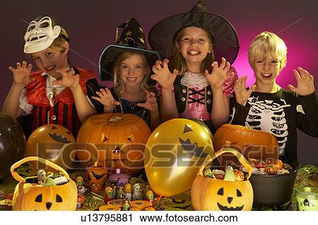 Stock Image - Halloween party with children wearing fancy costumes. Fotosearch