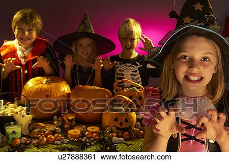 Stock Image - Halloween party with children wearing scaring costumes. Fotosearch