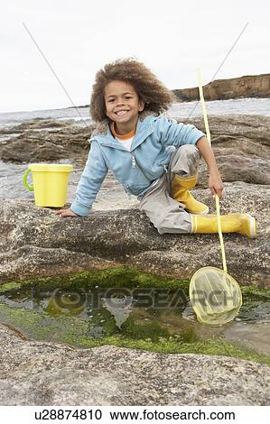 Stock Image - Happy boy with fishing net. Fotosearch