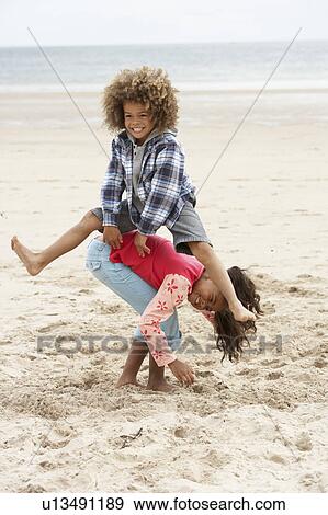 Stock Photo - Happy children playing on beach. Fotosearch