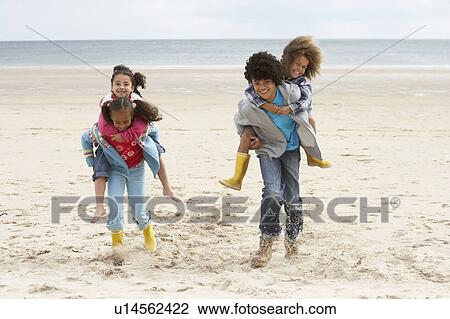 Happy children playing piggyback on beach View Large Photo Image Stock Image - Happy children playing piggyback on beach. Fotosearch