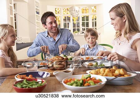 Happy family having roast chicken dinner at table View Large Photo Image Stock Photo - Happy family having roast chicken dinner at table. Fotosearch