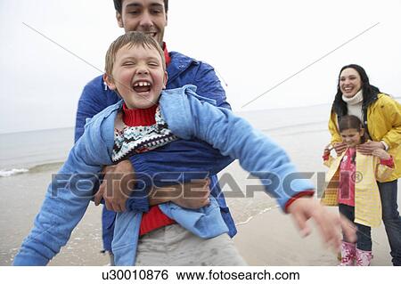 Stock Photograph - Happy family on beach. Fotosearch