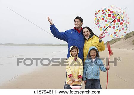 Happy family on beach with umbrella View Large Photo Image Stock Image - Happy family on beach with umbrella. Fotosearch