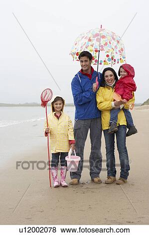 Happy family on beach with umbrella View Large Photo Image Stock Photo - Happy family on beach with umbrella. Fotosearch