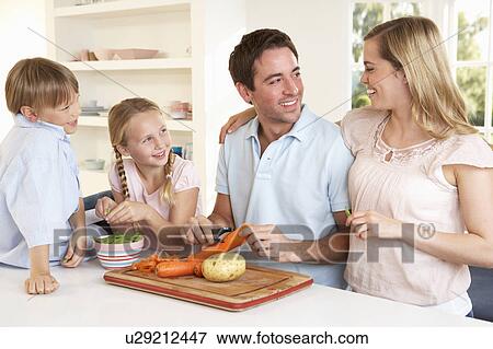 Happy family peeling vegetables in kitchen View Large Photo Image Stock Photo - Happy family peeling vegetables in kitchen. Fotosearch