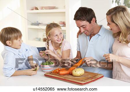 Happy family peeling vegetables in kitchen View Large Photo Image Stock Photography - Happy family peeling vegetables in kitchen. Fotosearch