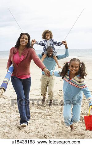 Happy family running on beach View Large Photo Image Stock Image - Happy family running on beach. Fotosearch