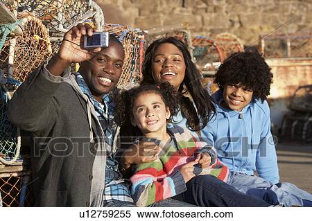 Stock Photography - Happy family taking photo. Fotosearch