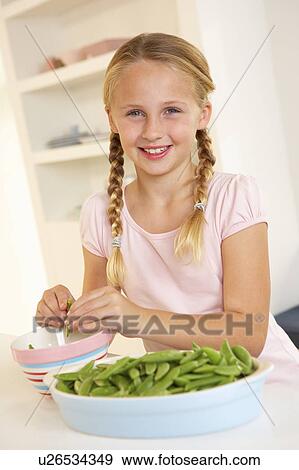 Happy girl splitting peas in kitchen View Large Photo Image Stock Photo - Happy girl splitting peas in kitchen. Fotosearch